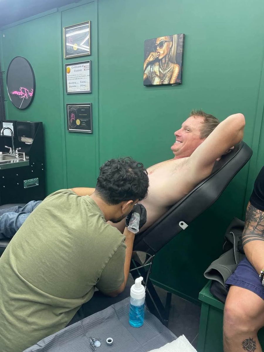 A friend smiling during a Party. tattoo session